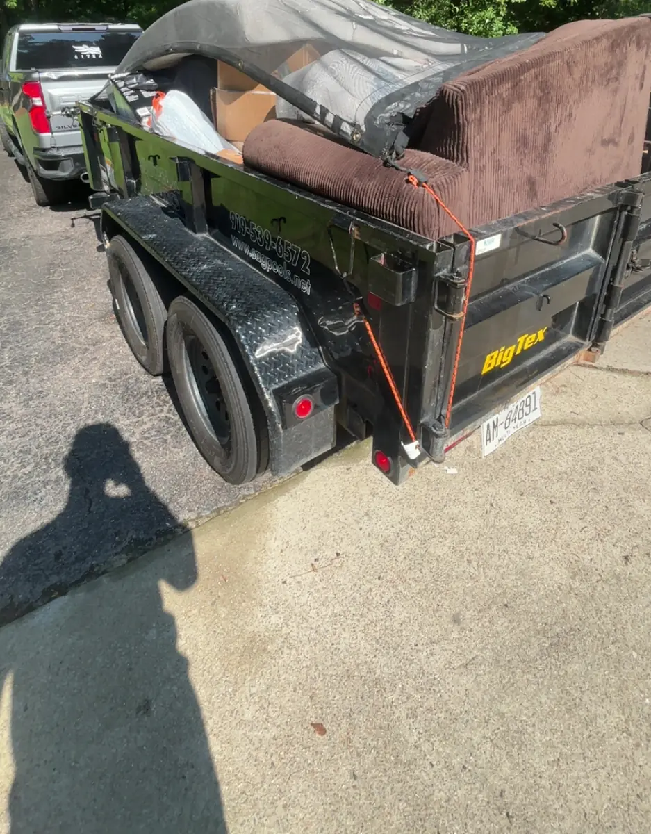 Loaded trailer with a couch and boxes from a move-out cleanout